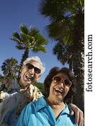 Senior Hispanic couple laughing outdoors