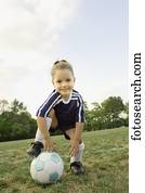 Young girl in athletic gear with soccer ball 