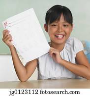 Asian girl holding up school paper with A+