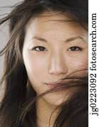 Close up of young Asian woman with hair in face