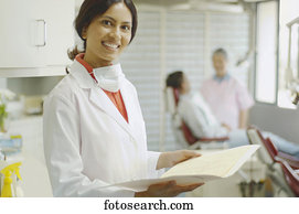 Indian female dentist holding chart and smiling