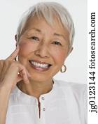 Studio shot of senior Asian woman smiling