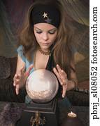 Woman dressed at fortune teller looking into crystal ball
