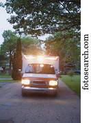 ambulância, com, luzes, ligado, dirigindo, em, área residencial