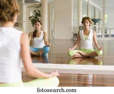 Two women meditating in front of mirror