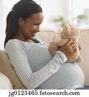 grávida, mulher africana, abraçando, urso teddy