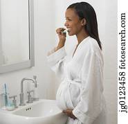 Pregnant African woman brushing teeth