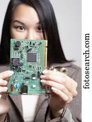 Asian businesswoman holding up computer circuit board