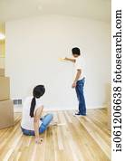 Asian couple looking at paint swatches in new house