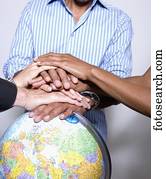 Multi-ethnic businesspeople with hands on globe