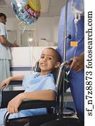African boy being pushed in wheelchair in hospital