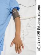 African child’s arm with blood pressure cuff in hospital bed