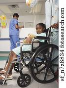 African girl being pushed in wheelchair in hospital