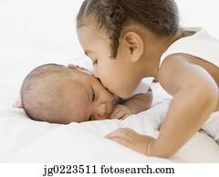 African girl kissing newborn baby sibling