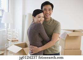 Asian couple hugging in new house