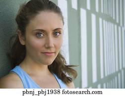 Close up of young woman leaning against wall