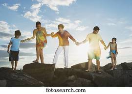 Low angle view of Hispanic family holding hands on rocks