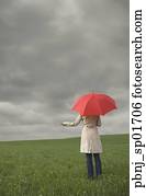 Rear view of woman holding umbrella in field
