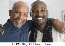 African father and adult son hugging