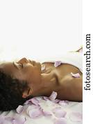 African woman laying on spa table