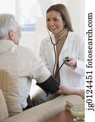 Hispanic female doctor taking patient’s blood pressure
