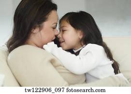 Hispanic mother and daughter smiling at each other