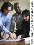 Multi-ethnic businesspeople looking at blueprints
