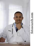 African doctor writing in notebook