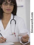 Female doctor handing over prescription