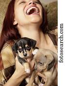 mulher hispânica, segurando, filhotes cachorro