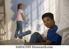 Asian couple painting interior of house