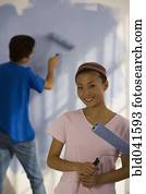 Asian couple painting interior of house
