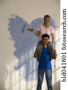 Asian couple painting interior of house