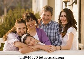 Hispanic family hugging on porch