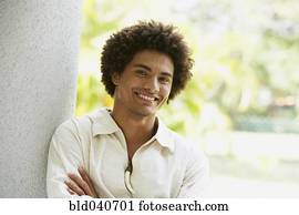 South American man leaning on column