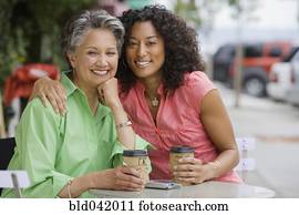 African American mother and adult daughter hugging