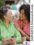 African American mother and adult daughter smiling at each other