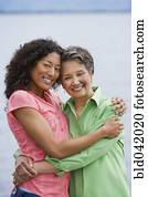 African American mother and adult daughter hugging