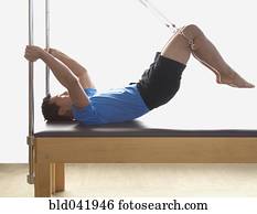Asian man stretching on exercise equipment