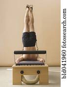 Asian man stretching on exercise equipment