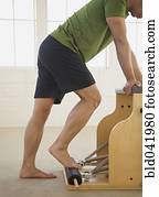 Asian man stretching on exercise equipment