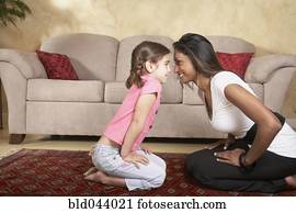 Indian mother and daughter smiling at each other