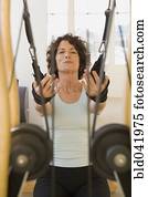 Senior woman stretching on exercise equipment