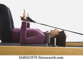 Senior woman stretching on exercise equipment