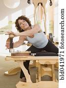 Senior woman stretching on exercise equipment