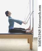 Woman stretching on exercise equipment