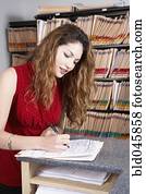 Hispanic female medical professional writing on chart