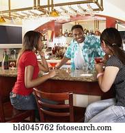 Multi-ethnic women sitting at bar