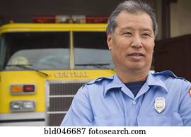 Asian male paramedic in front of ambulance