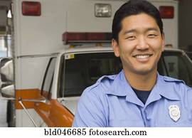 Asian male paramedic in front of ambulance